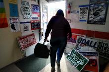 Bunny Pfau carries a loudspeaker out to a waiting car as members of the Boulder County Democrats clean up after a party Tuesday night. 